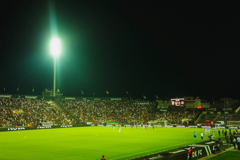 Pertandingan sepak bola di stadion dengan lampu sorot malam