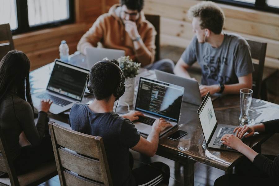 Laptop menampilkan permainan meja sebagai ruang kerja tim editorial